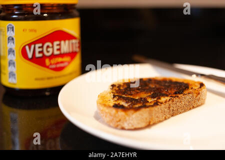 Sydney, Australien - 2 November, 2019 - Vegemite Toast und Butter auf Sauerteig, Messer und Vegemite jar. Ein klassisches Symbol der Australischen ausbreiten. Stockfoto