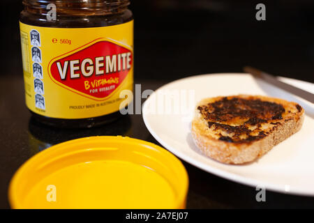 Sydney, Australien - 2 November, 2019 - Vegemite Toast und Butter auf Sauerteig, Messer und Vegemite jar. Ein klassisches Symbol der Australischen ausbreiten. Stockfoto