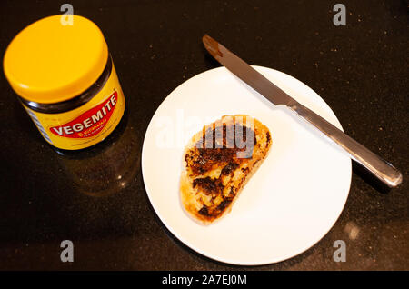 Sydney, Australien - 2 November, 2019 - Vegemite Toast und Butter auf Sauerteig, Messer und Vegemite jar. Ein klassisches Symbol der Australischen ausbreiten. Stockfoto