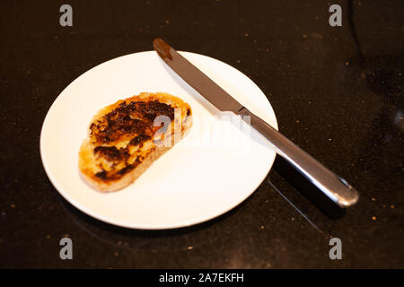 Vegemite Toast und Butter auf sauerteig mit Messer an. Ein klassisches Symbol der Australischen ausbreiten. Stockfoto