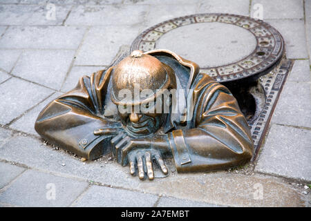 Street Art in Form einer Bronzestatue "Der Beobachter, der aus einem imaginären Mannloch in Bratislava Slowakei wird angezeigt Stockfoto