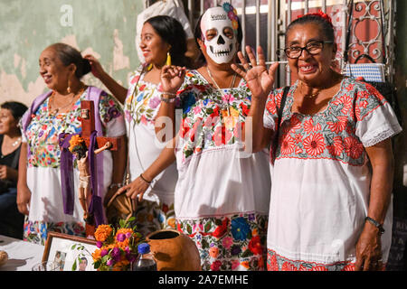 Frauen, die vor ihren Familie Hanal Pixan Altar während der Feier des Tages der Toten, die von der Maya-kultur stammt. Merida, Yucatan, Mexiko Stockfoto