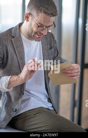 Man Gefühl aufgeregt vor dem Lesen Brief von seinem alten Freund Stockfoto