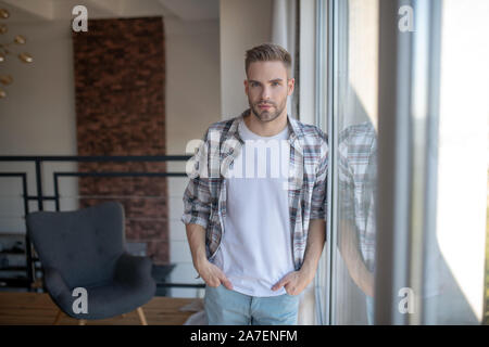 Stilvolle Mann, kariertes Hemd in der Nähe der Fenster stehen Stockfoto