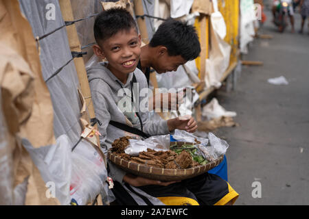 Zwei Jungen, die durch den Verkauf von Waren auf der Straße innerhalb der CO2-Markt, Cebu City, Philippinen Stockfoto