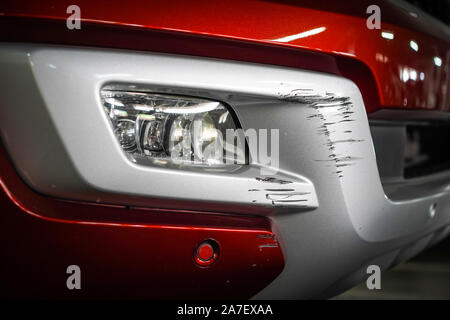 Close up neue Scratch Schäden an der Vorderseite des neuen roten Auto. Stockfoto