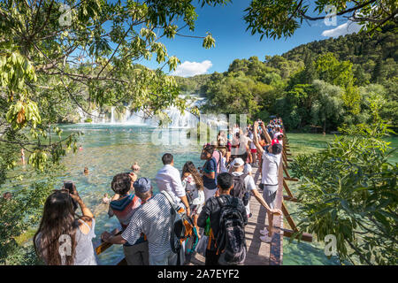 Touristen auf der Brücke beobachten, Wasserfälle im Nationalpark Krka in Kroatien Stockfoto