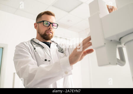 Junger Arzt stand vor der Moderne medizinische Ausrüstung Bärtigen Stockfoto