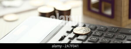 Münze lag auf Rechner, Haus Modell auf Büro Schreibtisch Stockfoto