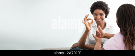 Porträt eines lächelnden Afrikanische junge Frau Lehre ihren Freund Hand Gebärdensprache Stockfoto