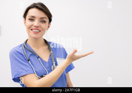 Junge weibliche Kliniker mit toothy Lächeln, die Präsentation der neuen Medizin Stockfoto