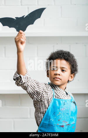 Afrikanische Knabe in der blauen Schürze Holding handgefertigte halloween Symbol Stockfoto