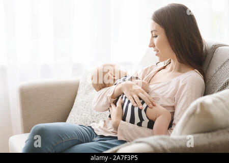 Charmante neugeborenes Baby schlief auf Arm der Mutter nach dem Stillen