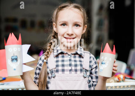 Süß lächelnd Schulmädchen, scary halloween Spielzeug von Papierrollen gemacht Stockfoto