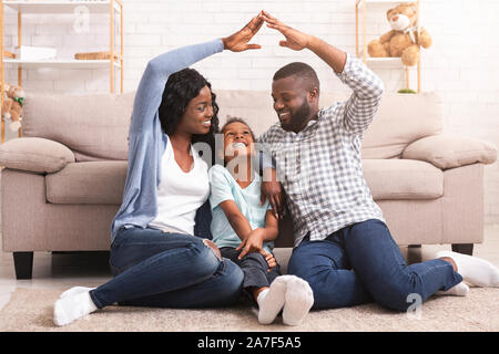 Schwarze Familie, die symbolische Dach der Hände über kleine Mädchen Stockfoto