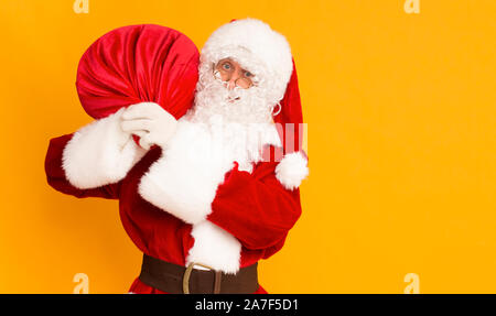 Santa Claus harring präsentiert von grossen roten Sack zu geben Stockfoto