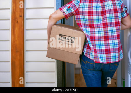 Tambow, Russische Föderation - September 04, 2019 Frau mit Ikea Karton geht in ein Haus. Close-up. Stockfoto