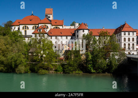 Blick auf Füssen Museum und Basilika St. Mang von der Südseite der Lech mit einem klaren blauen Himmel im Hintergrund. Stockfoto