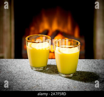 Zwei Eierlikör Gläser am Kamin, Abend Stockfoto