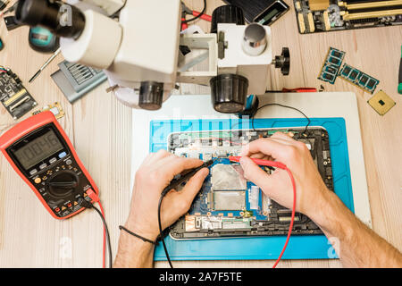 Überblick über die Hände der professionellen Handwerker mit Löten - Eisen während der Arbeit Stockfoto