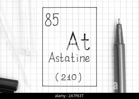 Das Periodensystem der Elemente. Handschrift chemische Element Astat an mit schwarzem Stift, Reagenzglas und Pipette. Close-up. Stockfoto