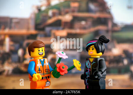 Tambow, Russische Föderation - Februar 24, 2019 Lego harten Hut Emmet mit Blumen und Lucy minifiguren an einander gegen Apocalypseburg Stockfoto