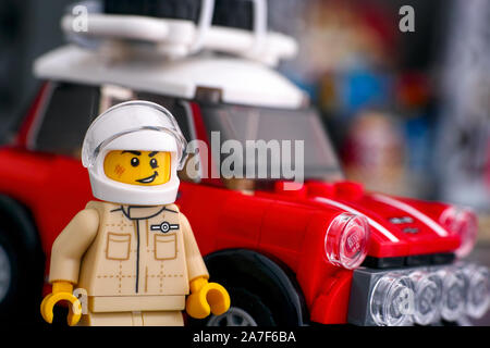 Tambow, Russische Föderation - August 18, 2019 Lego 1967 Mini Cooper S Rallye Fahrer minifigur von LEGO Speed Champions in der Nähe von seinem Auto. Stockfoto