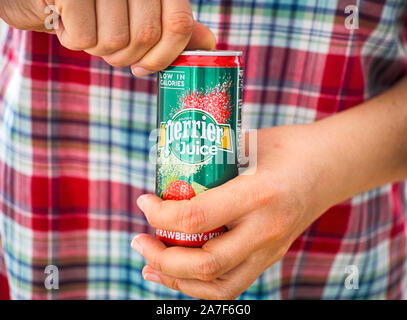 Tambow, Russische Föderation - September 04, 2019 Frau Hände öffnen Perrier und Saft Wasser kann. Close-up. Stockfoto