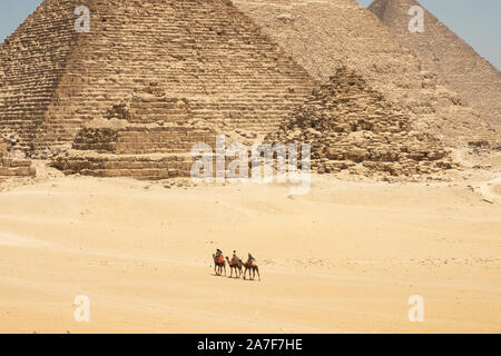 Touristen auf Kamele sehen Khufu, Khafre, Menkaure und Pyramiden von Königinnen aus Wüste. Stockfoto