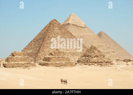 Touristen auf Kamele sehen Khufu, Khafre, Menkaure und Pyramiden von Königinnen aus Wüste. Stockfoto