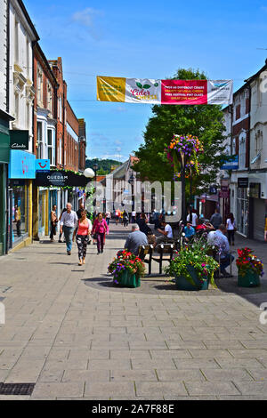 Ein Blick auf die geschäftigen und hektischen Middle Street, eine der wichtigsten Einkaufsstraßen von Yeovil. Käufer entlang wandern. Pretty Woman in farbenfrohem Outfit. Stockfoto