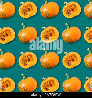 Geometrische Anordnung der Reife orange Kürbisse auf dunkelgrünem Hintergrund, bunte Gemüse Textur, vegane Ernährung, Herbst Halloween Hintergrund Stockfoto