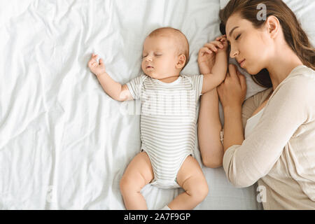 Junge Mutter und niedlichen Baby co-zusammen schlafen im Bett. Stockfoto