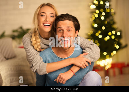 Glückliches Paar genießen Heiligabend vor Xmas Tree Stockfoto