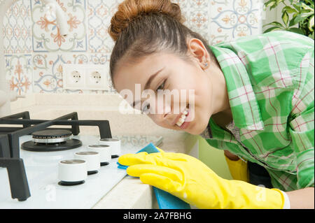 Behandschuhten Hausfrau wäscht Schränke, Herd und Spüle in der Küche Stockfoto