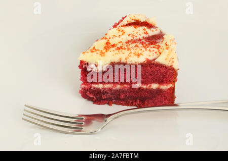 Nahaufnahme von einer Scheibe der Red Velvet Cake auf einem Teller mit der Gabel Stockfoto