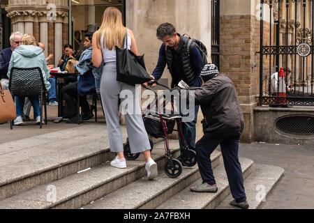 Eine ältere Dame ist geholfen, die Schritte zur Liverpool Street Station von gutherzige Passanten klettern durch. London, Großbritannien Stockfoto