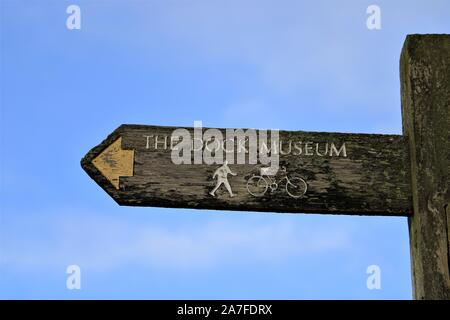 Wegweiser Richtung für das Dock Museum aus dem Channelside, Barrow-In-Furness, Cumbria, Großbritannien. Stockfoto