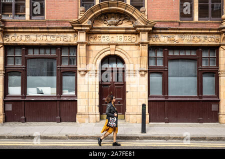 Eine Dame an Gebäude aus dem Jahre 1902. Über der Tür Datensätze der ursprüngliche Zweck war es, eine Suppenküche für die Armen Juden in East London, UK Stockfoto