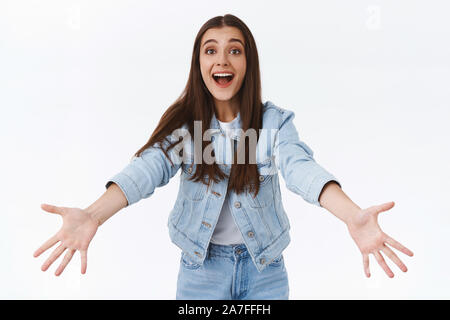 Zart und freundlich charmante brunette Mädchen in Jeans Jacke, Jeans finden Sie Freund und breitete die Hände willkommen, jemand zu, warme Umarmungen oder Knuddel, lächelnd Stockfoto