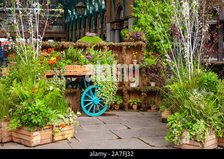 London, Großbritannien. 02-05-2019. Covent Garden Market. Blumen und Pflanzen auf einem Markt wagen Anzeige im Quadrat der restaurierten Markt Gebäude. Stockfoto