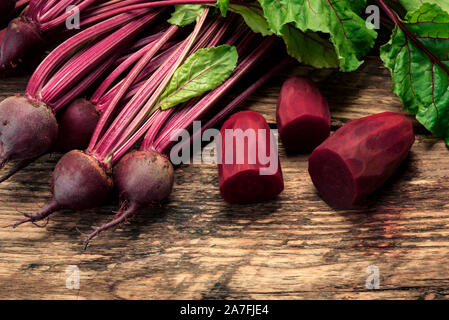 Bio rote Bete mit Kräuter grüne Blätter auf einem rustikalen Holztisch. Stockfoto