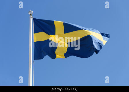 Flagge Schwedens winken an einem klaren blauen Himmel Hintergrund in close-up (hoch) Stockfoto