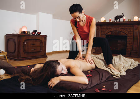 Entspannende Massage für Paare in vier Hände. Vierhändige Massage ist eine Massage, wo zwei Therapeuten arbeiten, auf die Sie gleichzeitig, Spiegelung, jede andere Stockfoto