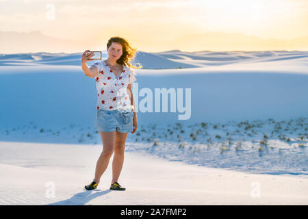 Frau unter selfie Bild auf Sand Hill in White Sands Dunes National Monument in New Mexico phone mit Wind Stockfoto