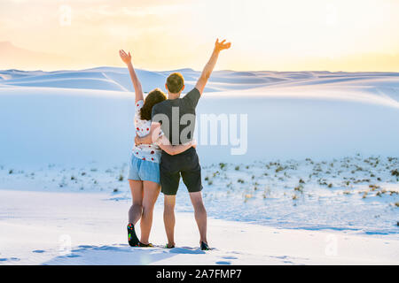 Frau und Mann junges Paar stehend auf Sand Hill in White Sands Dunes National Monument in New Mexico mit Sonnenuntergang Stockfoto