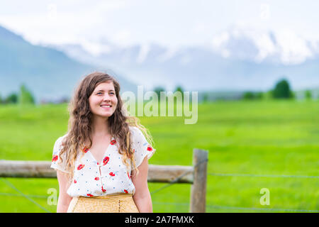 Crested Butte, Colorado Landschaft mit glückliche junge Frau, die durch Zaun und im Sommer mit grünem Gras und Alpine Mountain View Stockfoto