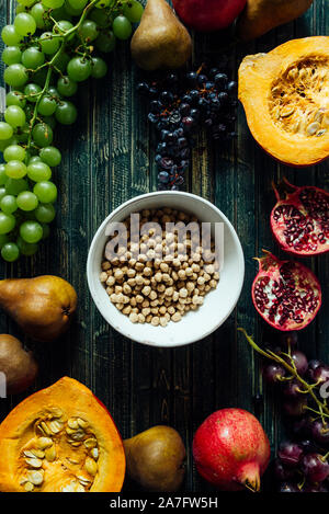 Die herbstlichen Obst, gesundes Müsli Hintergrund, typischen Früchte der herbstlichen Jahreszeit, biologisch angebaute, runden Schalen voller gesunder Getreide Hafer Stockfoto