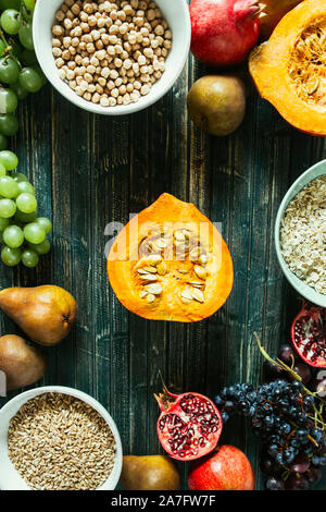 Die herbstlichen Obst, gesundes Müsli Hintergrund, typischen Früchte der herbstlichen Jahreszeit, biologisch angebaute, runden Schalen voller gesunder Getreide Hafer Stockfoto