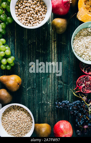 Die herbstlichen Obst, gesundes Müsli Hintergrund, typischen Früchte der herbstlichen Jahreszeit, biologisch angebaute, runden Schalen voller gesunder Getreide Hafer Stockfoto